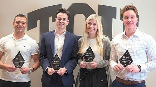 Sales team members with trophies.