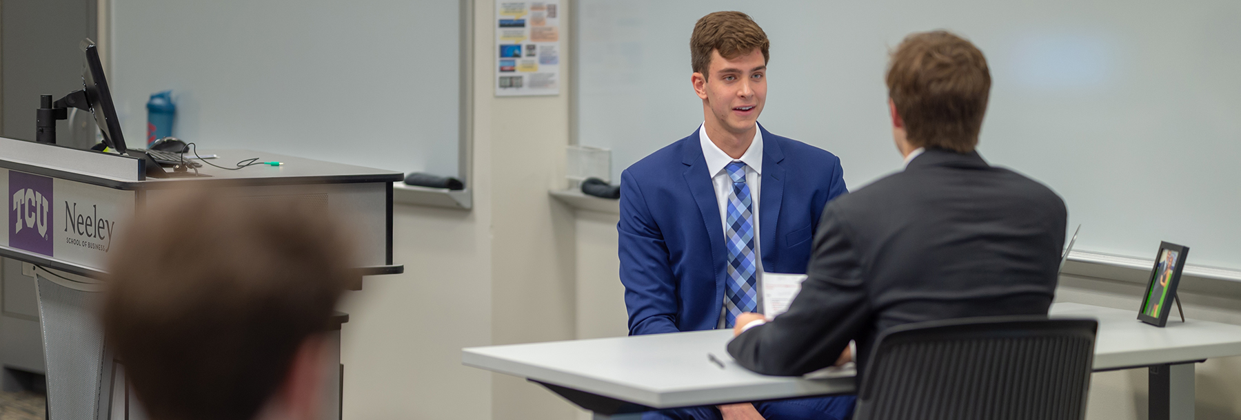 Section Image: Students in class sitting across a table from each other 