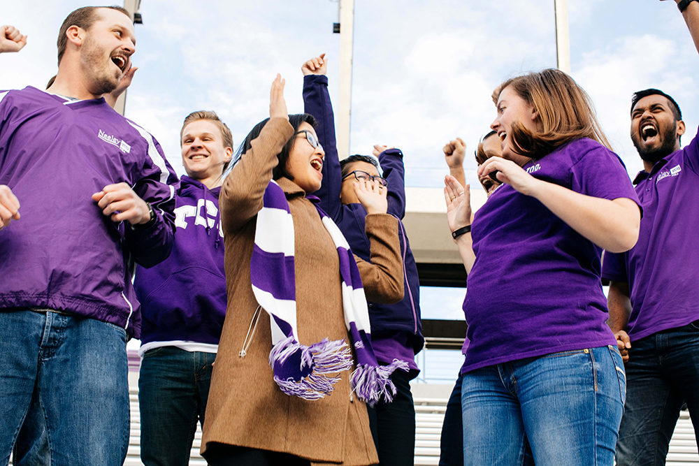 students in purple cheering on the Frogs