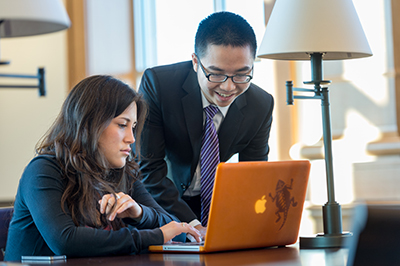 man and woman looking at laptop screen