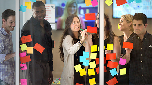 Section Image: Stacy Grau and students with post-it notes 