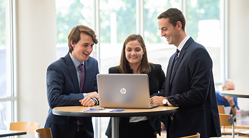 Section Image: three students at a laptop 