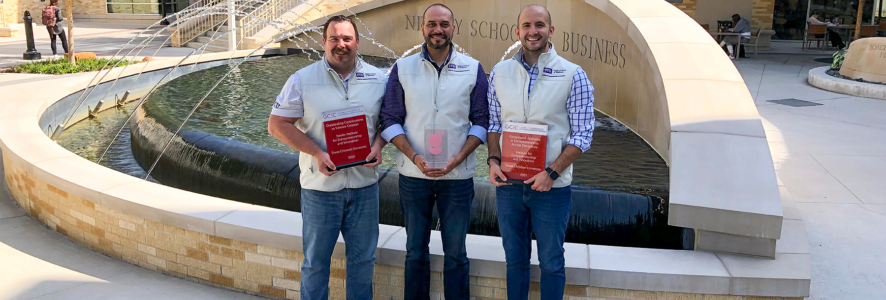 Section Image: Matt Smilor, Rodney D'Souza and Antonio Banos with GCEC awards in front of the Neeley fountain 