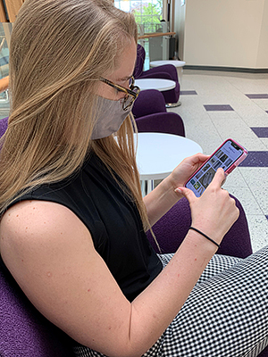 Student shopping on eBay on her phone in the Neeley building