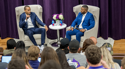 Section Image: Sekou Lewis and David Russell sit on the stage with microphones at the event. 