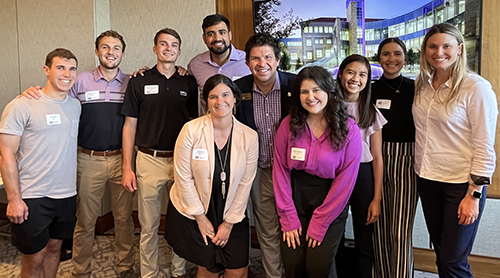 Section Image: Large group of alumni from Austin pose with Frogs Up with Dean Daniel Pullin. 