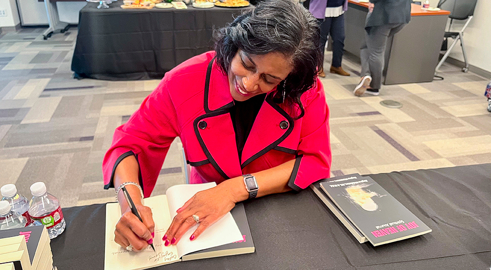 Regina Middleton signing a copy of her book