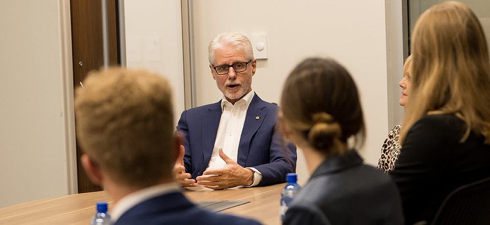 Phillip Green addressing students at a conference room table