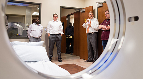 MRI machine with people discussing it in the background