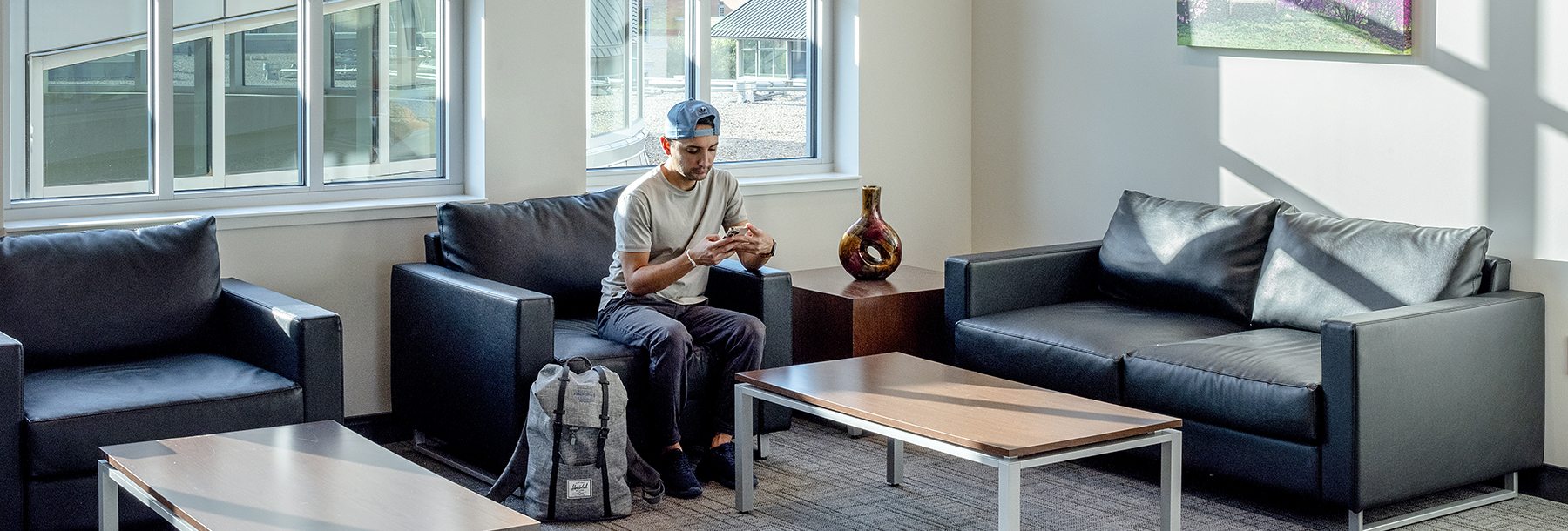 Section Image: Fourth floor lounge with student sitting on a couch 