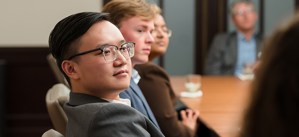 Section Image: students at a conference table 