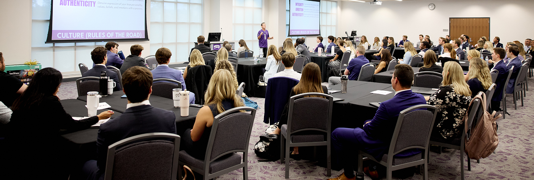 Section Image: Corey Hutchison addressing a group in the Hays Banquet Hall 