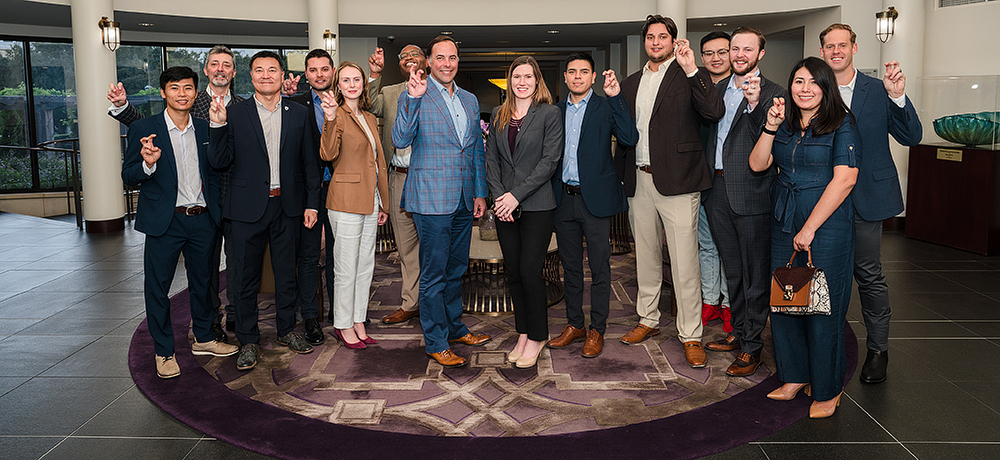 Section Image: Graduate students in the Dee J. Kelly Alumni and Visitors Center with their frogs up 