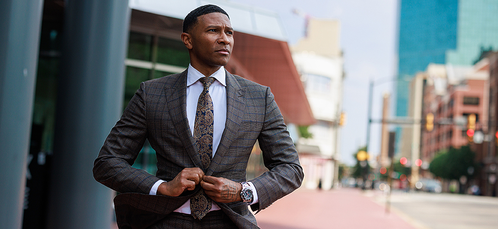 Section Image: A student downtown Fort Worth buttoning his suit coat 