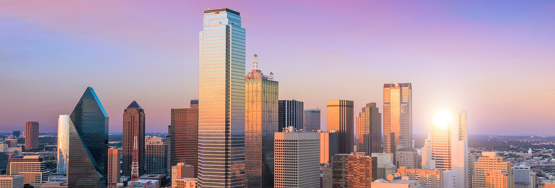 Section Image: Dallas skyline with a purple sunset behind it 
