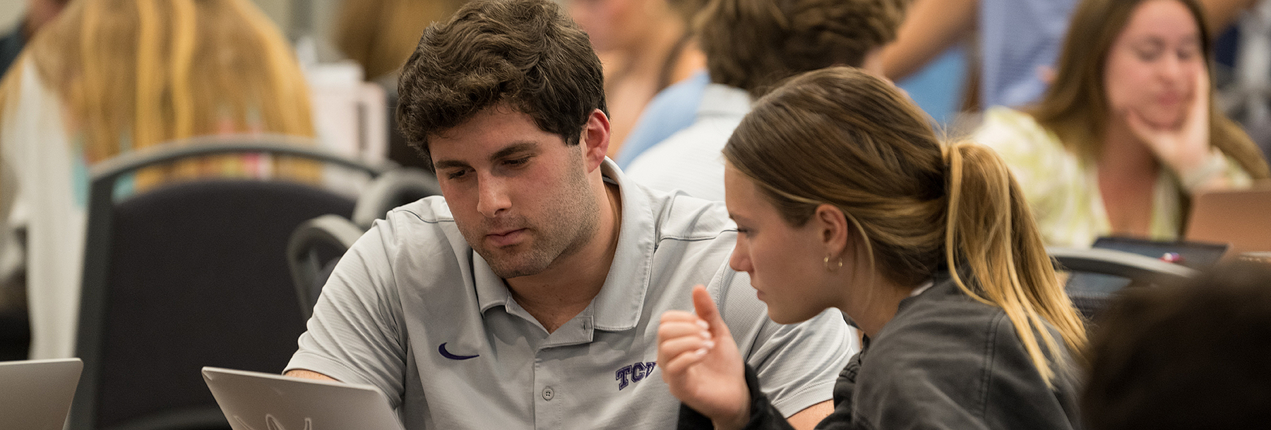 Section Image: Male and female student at table in the Banquet Hall looking at a laptop 