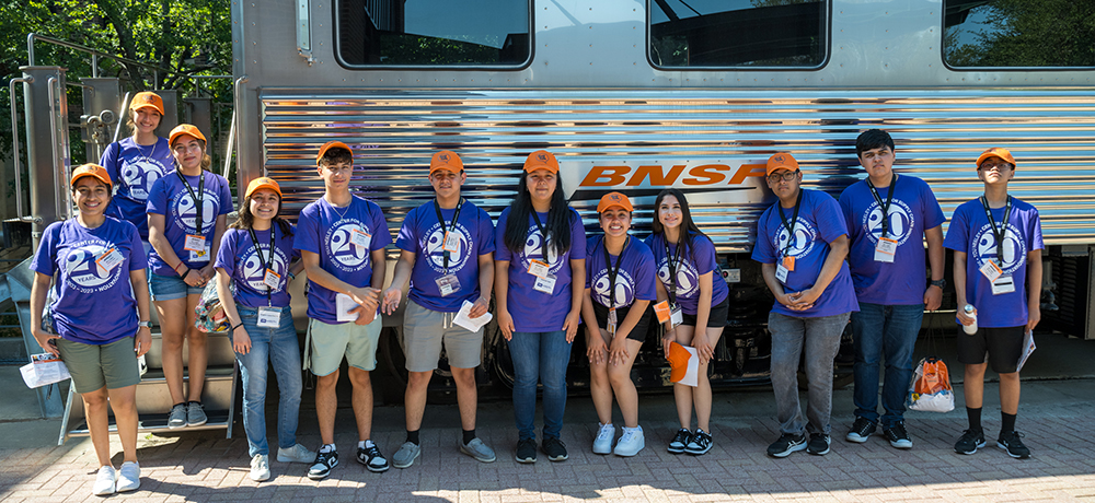 Camp attendees standing with a BNSF railway car