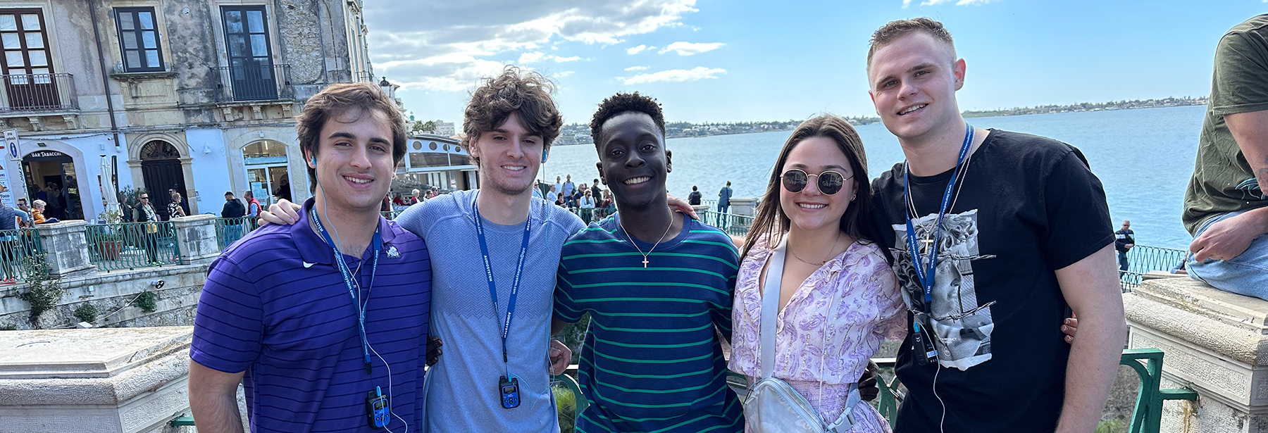 Section Image: Five Neeley students abroad post with the ocean in the background 