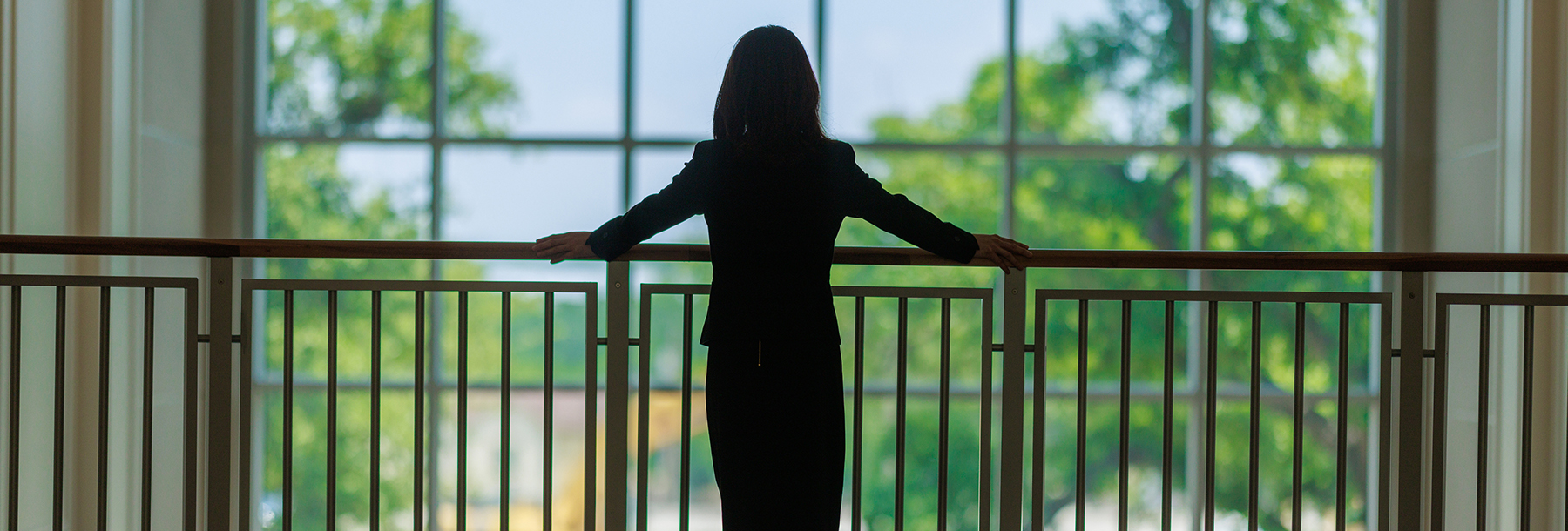 Section Image: Woman standing at the balcony in Hays Hall 