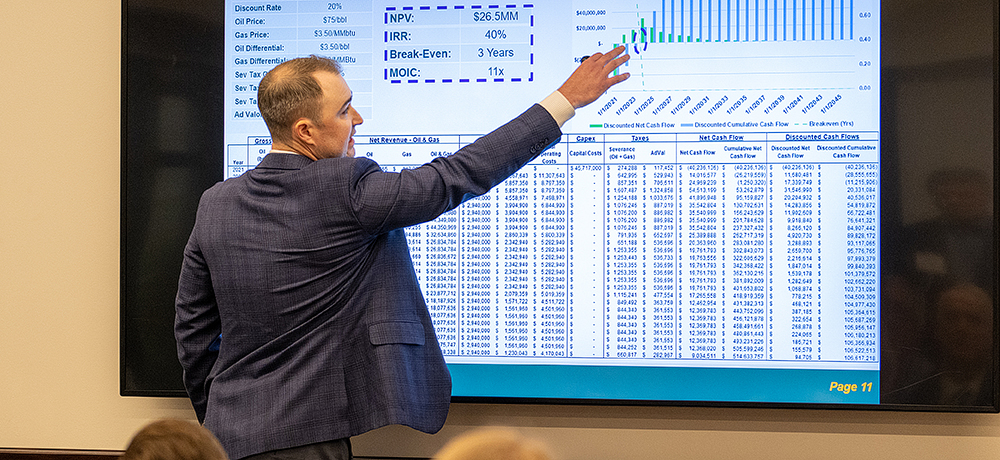 Section Image: Man presenting a complex chart on screen 