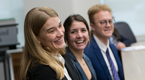Students at a conference table with podium in background