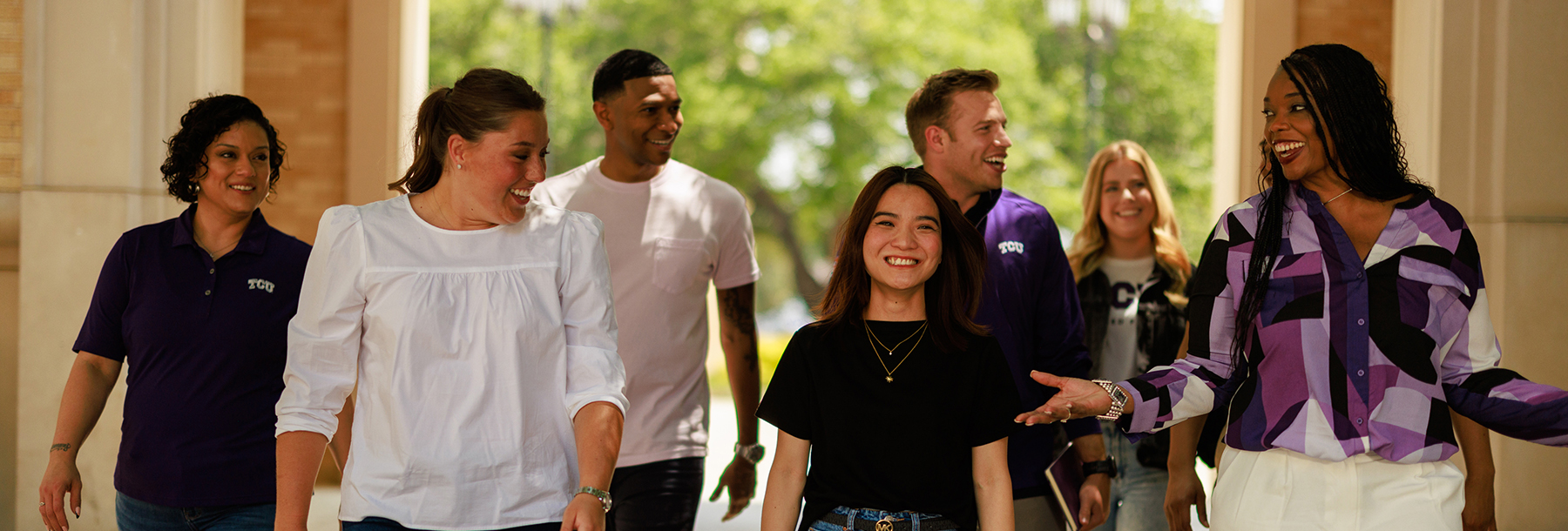 Section Image: Group of students and adults walking outside in the breezeway 