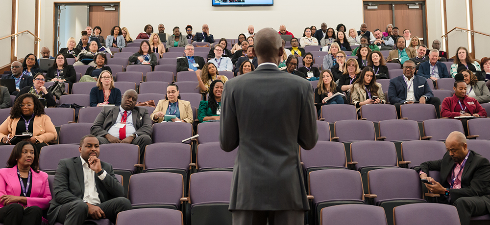 Speaker addressing DEI conference attendees in the Shaddock Auditorium