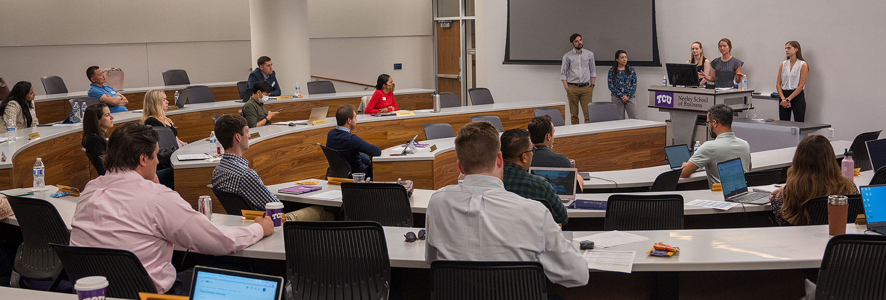 Section Image: Students giving a presentation in Neeley 1201 