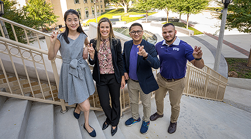 Four students on the stairs outside the Neeley Business Commons