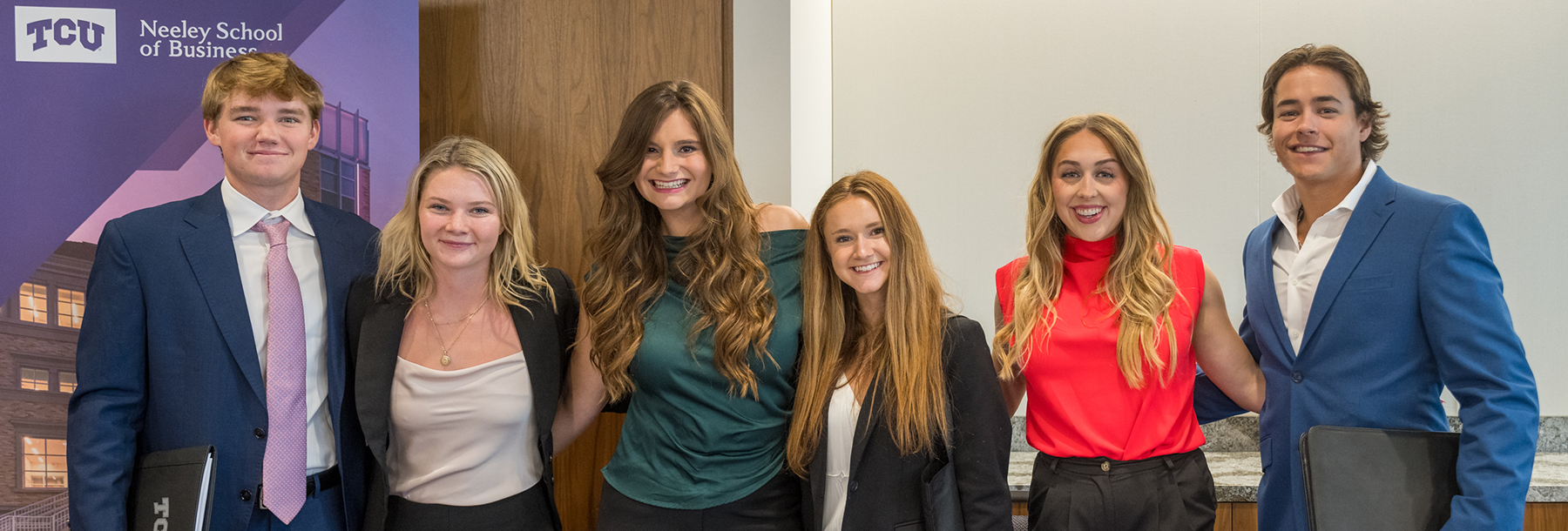 Section Image: Sales Center students by a pop up sign 