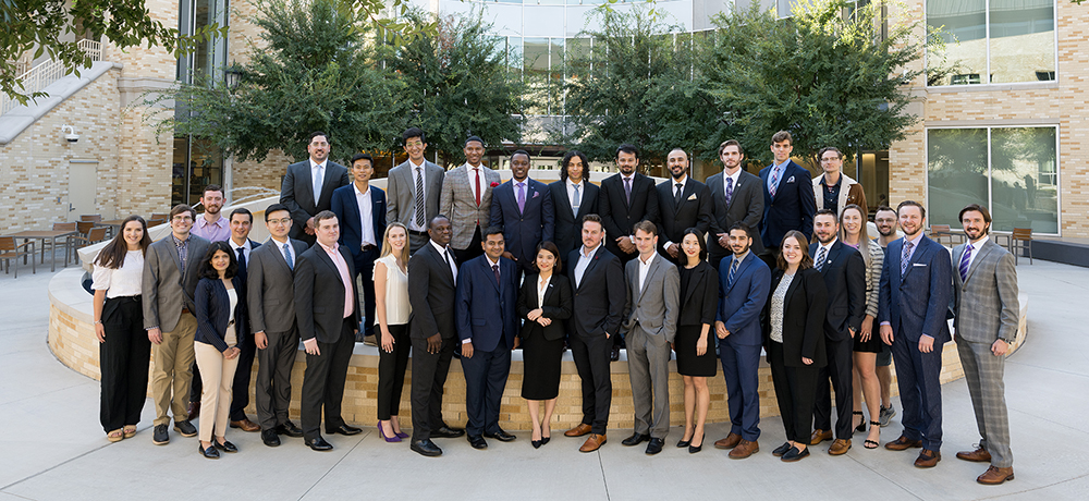 Full-time MBA students in suits by the Neeley Fountain