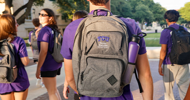 Neeley Analytics Academy students wearing TCU NAI branded backpacks and shirts