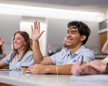 Students raising hands to answer in class